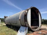 a large metal pipe sitting in the middle of a field