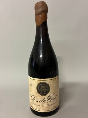 an old bottle of wine sitting on top of a table