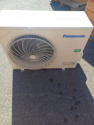 un climatiseur posé par terre devant une pile de cartons