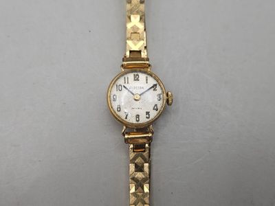 an image of a woman ' s wrist watch sitting on a white surface