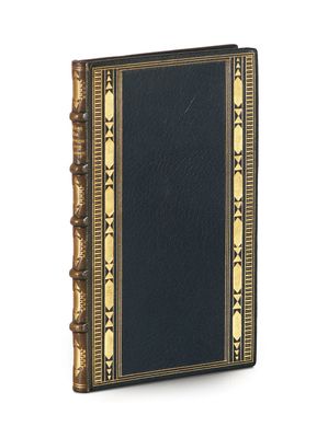 an old black book with gold trim on a white background
