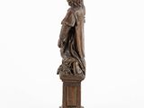 a wooden statue of a man with a dog on a pedestal