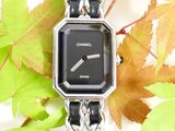 a watch that is sitting on a chain with leaves in the background