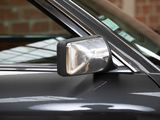 a close up of a car ' s side mirror with a brick wall in the background