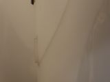 a toilet in a small bathroom with a toilet paper dispenser on the wall
