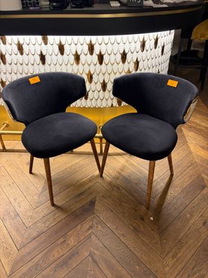 pair of mid century style chairs in black velvet with gold accents