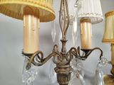 a chandelier with three lamps and a lamp shade on it