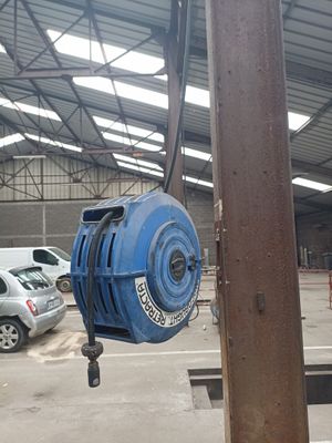 a blue fire hydrant hanging from the side of a pole