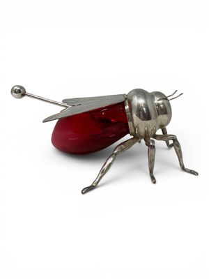 a metal insect with a red nose and legs