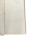 an open book with a handwritten page on it sitting on a white surface