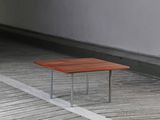 a wooden table sitting on a wooden floor in an empty room