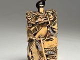 a close up of a gold and silver pendant on a black cord