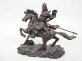 une statue représentant un homme à cheval sur un rocher