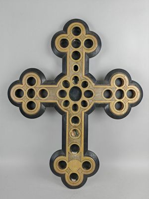 croix en bois rehaussée de touches noires et dorées sur fond blanc