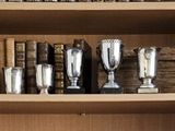 une bibliothèque remplie de trophées en argent et de livres