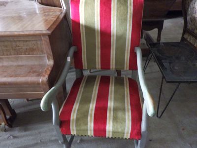 a red and green striped chair in the middle of a room