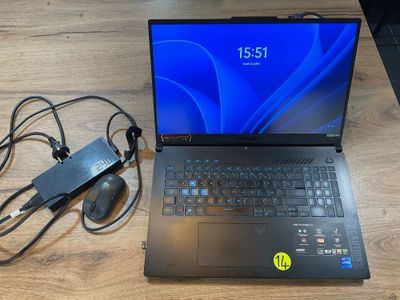un ordinateur portable posé sur une table, avec une souris et un chargeur