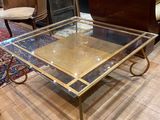 brass and glass coffee table on casteors