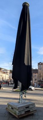 un parapluie noir posé sur un bloc de pierre