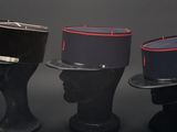 three hats on a black mannequin head on a black background