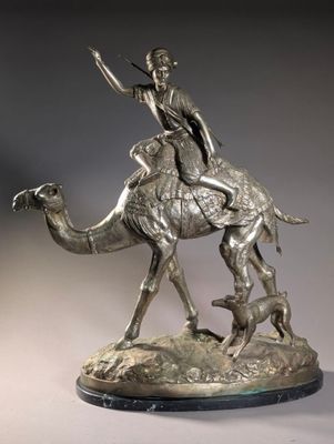bronze statue of a man riding a camel with a dog