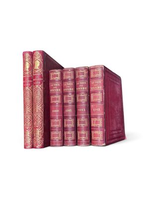 three books are stacked on top of each other on a white surface