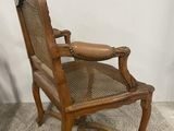 an old wooden chair sitting on top of a carpeted floor