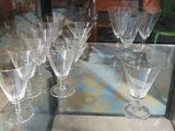 several empty wine glasses on a glass table in a glass case