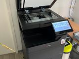 a printer sitting on top of a desk next to a laptop
