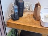 a picture of a phone on a wooden shelf in a bathroom