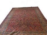 an antique persian rug with a red border and fringes