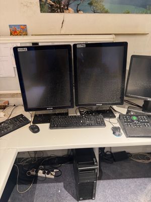 three computer monitors and a laptop on a desk