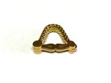 a gold plated metal object on a white surface