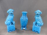 trois statuettes bleues « foo foo foo » posées sur un vase bleu