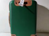 a green suitcase with a tag attached to it