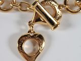 a gold bracelet with a heart and a lock on it