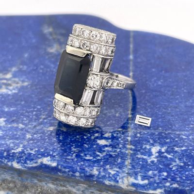 une image représentant une bague en diamant noir et blanc posée sur une pierre bleue