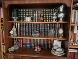 une bibliothèque sur laquelle se trouvent de nombreux livres et une horloge
