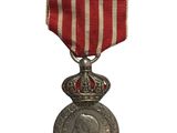 une vieille médaille ornée d'un ruban rouge et blanc sur fond blanc