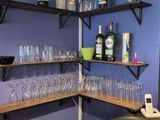 many empty glasses and bottles on the shelves in the kitchen