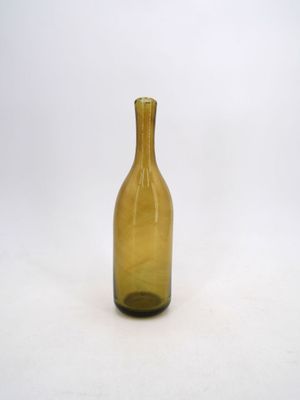 a yellow glass bottle sitting on a white surface