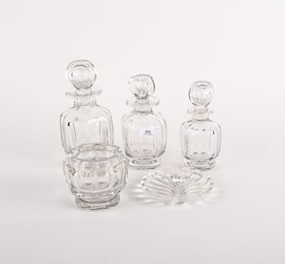 trois flacons de parfum en verre transparent posés les uns à côté des autres sur une surface blanche