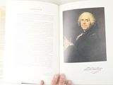someone is holding a book with a picture of a man in a black coat