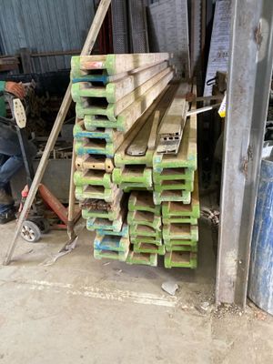 a man that is standing next to a pile of wood