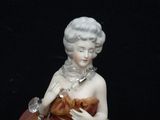 a figurine of a woman in a dress with a chain around her neck