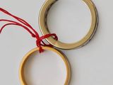 two rings with red string hanging from them on a white surface