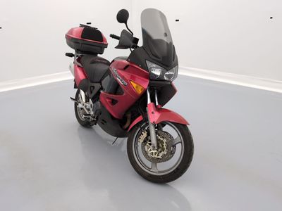 une moto rouge garée dans une pièce blanche
