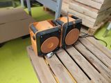 two speakers sitting on top of a wooden table