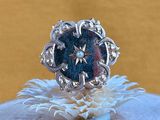 sterling silver ring with a blue stone center surrounded by white flowers