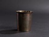a close up of a metal cup on a black surface